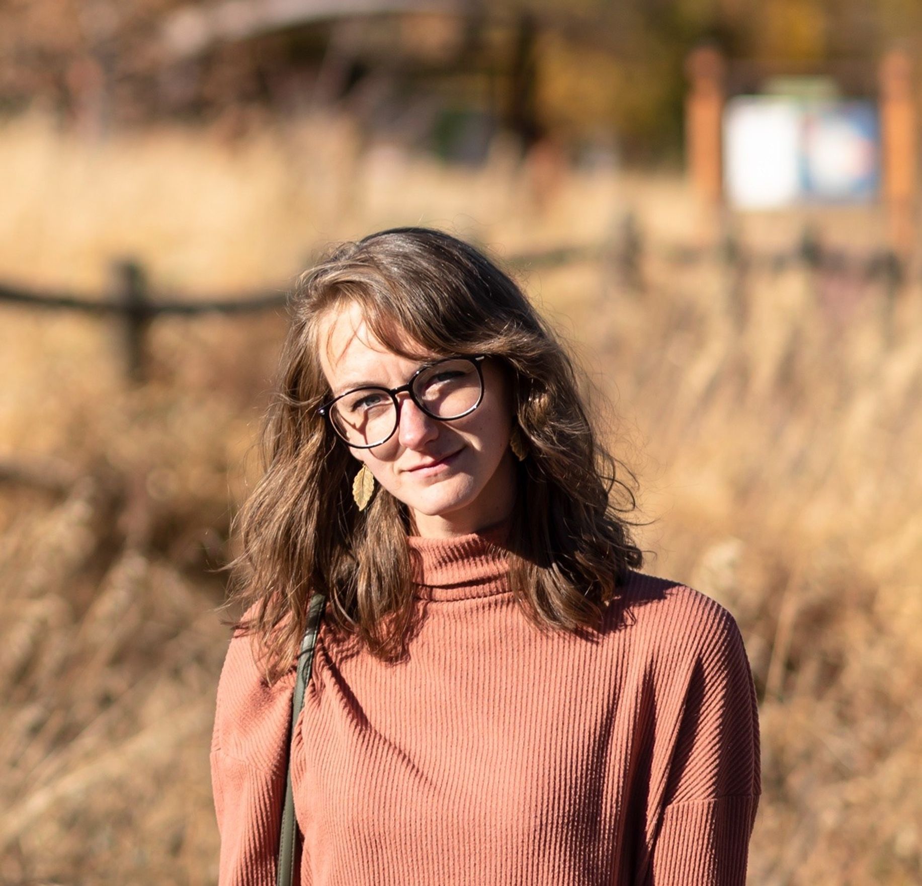 Portrait photo of a woman standing in a golden field