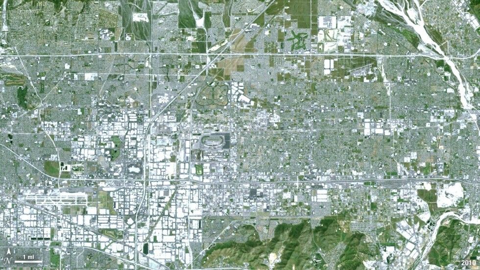 This natural color Landsat 5 image shows the city of Ontario, California, from above in the year 2010. The airport, found in the southwest portion of the image, added a number of runways since 1985, and large warehousing structures now dominate the once rural areas surrounding the airport. Vegetation is green and brown and urban structures are bright white and gray. There is a large dry riverbed in the northeast corner that is also bright white, but its nonlinear appearance sets it apart visually.